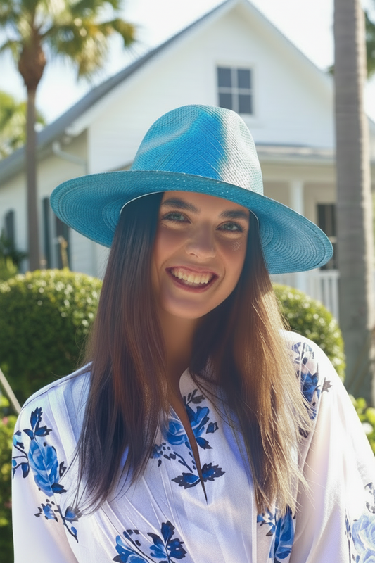 Woman wearing a blue hat and floral dress in a garden setting